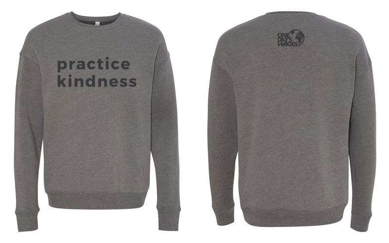 a gray crewneck with 'practice kindness' in a darker gray bold font on the front and the one day's wages logo on the back