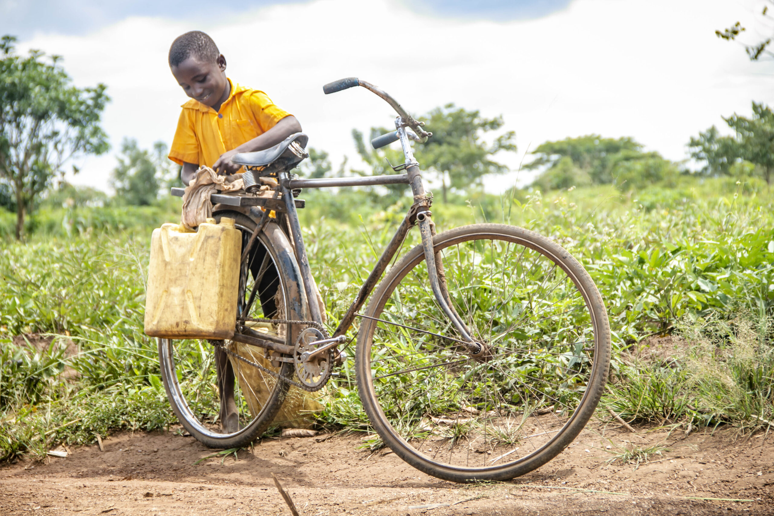 Boy with bike and water jerry can